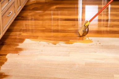 applying finish to hardwood floor with mop