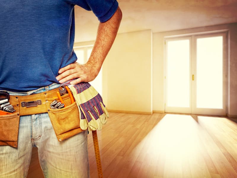 Worker in blue shirt with tools in a room